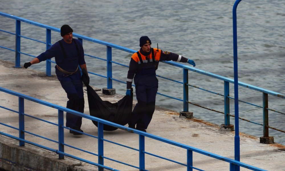 Сотрудники МЧС России переносят найденные на месте крушения предметы