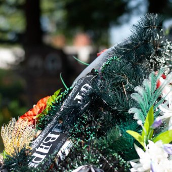 Памятник на кладбище в городе Береза, окруженный цветами и венками